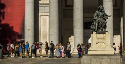 Una cola de visitantes en el exterior del Museo del Prado junto a la estatua de Velázquez.