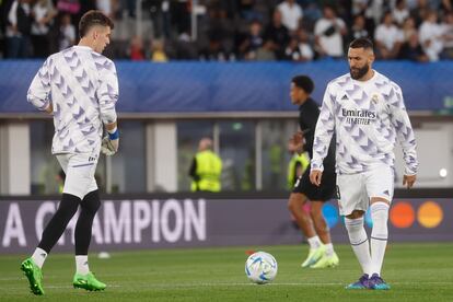 El delantero francés Karim Benzema (a la derecha) y el portero ucraniano, Andriy Lunin, calientan antes de la final de la Supercopa de Europa.