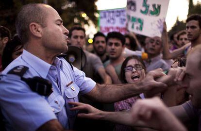 Un policía forcejea con varias personas durante la manifestación de hoy en Jerusalén.