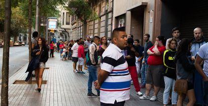 Decenas de personas hacen cola ante una comisar&iacute;a de Barcelona para conseguir cita para el DNI, en una imagen de julio de 2016.