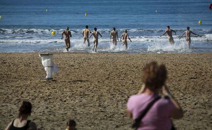 Varios jóvenes desnudos se tiran al agua en una de las playas de Salou.