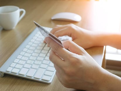 Una mujer compra en Internet con su tarjeta de crédito.