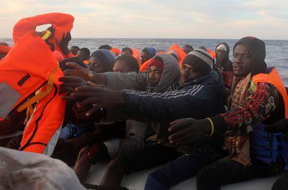 Un voluntario de la ONG lanza chalecos salvavidas a unos migrantes que atravesaban el Mediterráneo a la deriva el 1 de abril de 2017.