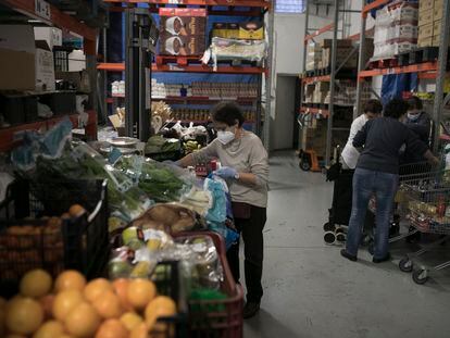 Voluntarios de Caritas preparan lotes de comida para usuarios del barrio del Eixample de Barcelona.