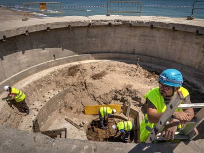 Un grupo de arqueólogos, en el hueco donde estaba la plataforma móvil con los cañones del búnker de El Saler, en Valencia.