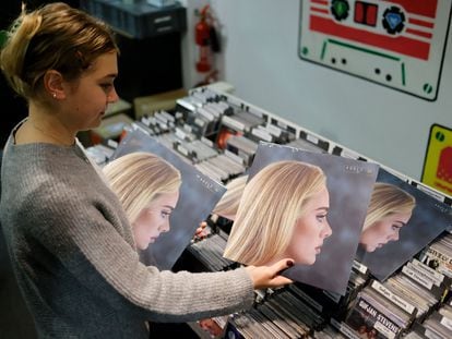 Empleada de una tienda del Soho londinense, con el disco ‘30′, de Adele.