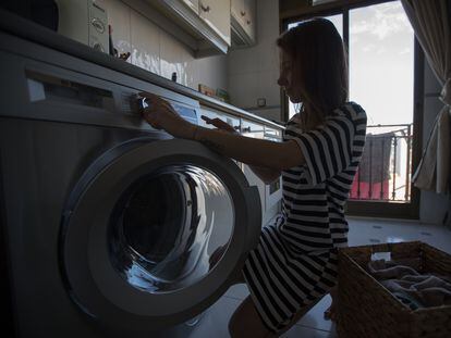 Una mujer pone la lavadora en su domicilio.