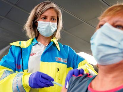 Una enfermera del servicio  SUMMA 112, vacuna a una mujer con la vacuna de AstraZeneca en el polideportivo WiZink, este miércoles.