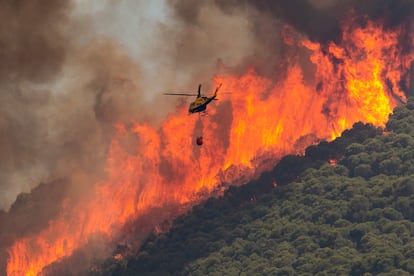 Un helicóptero trabaja en las tareas de extinción del incendio en el paraje El Higuerón de Mijas (Málaga). El incendio que afecta desde este viernes a la sierra de Mijas (Málaga) y a los municipios de Alhaurín el Grande y Alhaurín de la Torre, afecta a un perímetro de 1.890 hectáreas de terreno, y mantiene a 2.765 personas desalojadas de sus viviendas, ya que 300 de los 3.065 evacuados van a poder volver a sus casas.