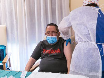 Una sanitaria vacuna contra el pasado domingo a Vicente Mirón, interno en una residencia de Mérida, el primer extremeño en ser inmunizado contra la covid.