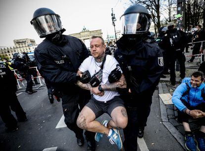 La policía se lleva detenido a un manifestante en la protesta de este miércoles en Berlín contra las nuevas restricciones que ha aprobado el Parlamento alemán.