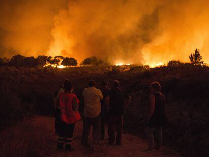 Amparanoia se topa con el fuego en la carretera. En la foto, vecinos de Devesa (Vilardevós) observan el incendio forestal declarado ayer.