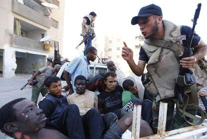 Un combatiente rebelde se dirige a un grupo de detenidos, el jueves durante los combates en Abu Salim.