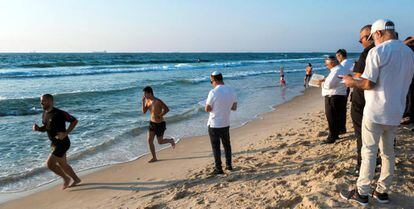 Israelíes religiosos rezan en el año nuevo judío mientras otros corren en una playa de Ashdod.