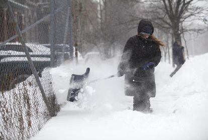 Una mujer limpia de nieve su casa en Detroit (Michigan).