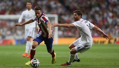 Saúl se marcha de Xabi Alonso en una acción del encuentro.