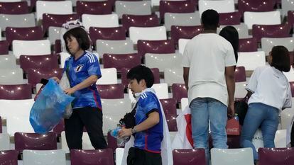 Aficionados japoneses recogen sus desperdicios en el estadio tras la victoria de su selección ante Alemania,  durante la Copa del Mundo organizada en Qatar, en noviembre de 2022.