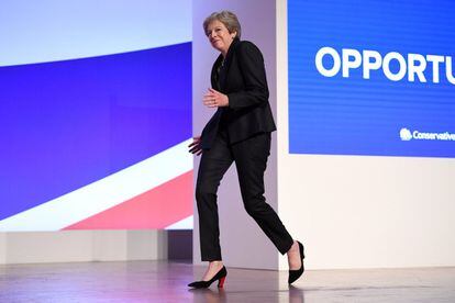 La Primera Ministra británica se acerca bailando al atril.