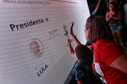 Simpatizantes de Lula da Silva siguen el conteo de los votos, este domingo en Brasilia.