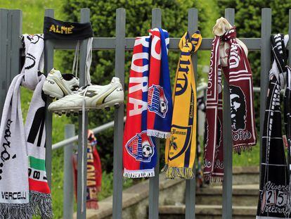 Zapatillas y bufandas cuelgan en una verja junto a la iglesia antes de comenzar el funeral del jugador del Livorno, Piermario Morosini.