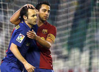 Xavi felicita a Iniesta durante el partido contra el Betis.