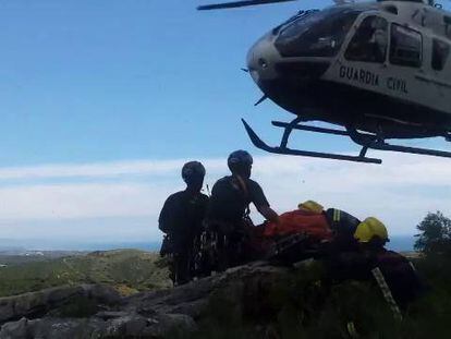 Evacuación del cadáver del piloto del helicóptero accidentado en Casares. Efectivos del Consorcio de Bomberos introducen el cuerpo en el helicóptero de la Guardia Civil.