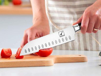 Una persona corta unos tomates utilizando un cuchillo de tipo Santoku.