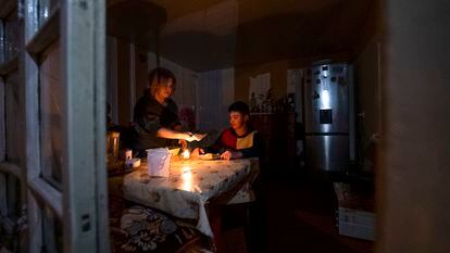 Una mujer y su hijo cenan en su casa de Stepanakert, el 18 de enero, a la luz de una vela debido a los cortes de electricidad por el bloqueo de Azerbaiyán al enclave armenio.