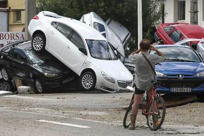 Un ciclista fotografía los vehículos apilados por la lluvia en Draguignan