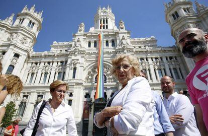 La alcaldesa de Madrid, Manuela Carmena, asiste al despliegue de la bandera arco iris en la fachada del Palacio de Cibeles.