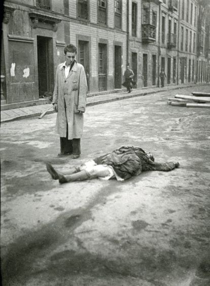 Un hombre observa el cadáver de una mujer en la calle San Bernabé de Oviedo en 1936.