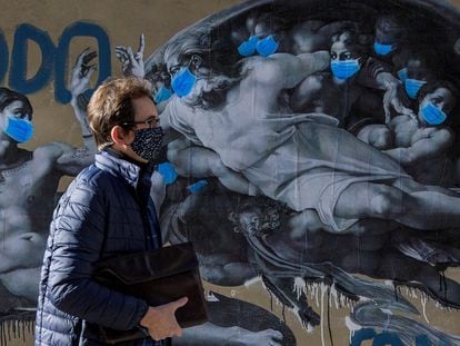 Un hombre pasa ante un mural del artista callejero Sentydo, en Pola de Siero (Asturias).