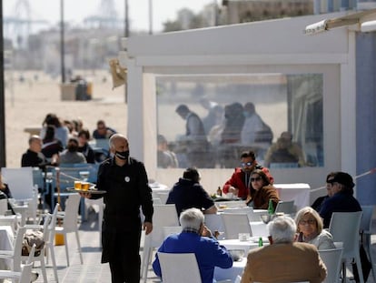 Un camarero atiende las mesas de una terraza en la playa de la Malvarrosa (Valencia), el 15 de marzo.