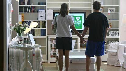 Una pareja se da la mano ante un salón vacío de un Ikea de Chicago.