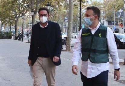 David Madí, acompañado de un Guardia Civil  llegando a su despacho del paseo de Gràcia de Barcelona. Foto: CRISTÓBAL CASTRO