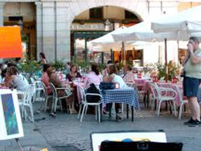 En la imagen, varios turistas toman un aperitivo en una terraza de la Plaza Mayor de Madrid.