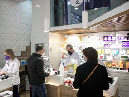 Dos clientes en la farmacia Dalmases de la calle de Aragón, en Barcelona, donde se notifican los positivos al sistema sanitario sin necesidad de desplazarse hasta un ambulatorio.