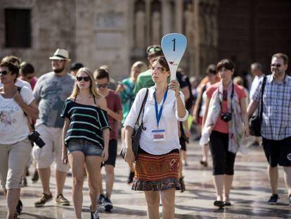 Un grupo de turistas sigue a su gu&iacute;a por el centro hist&oacute;rico de Valencia