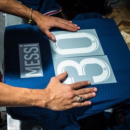 Un empleado prepara una camiseta de Messi con el número 30, este miércoles en una tienda oficial del PSG de París. Desde las primeras horas del d centenares de personas aguardaban la apertura de las tiendas oficiales del club parisino para hacerse con la nueva camiseta oficial del astro argentino.