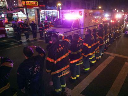 L'ambulància amb els agents assassinats passa davant dels bombers.