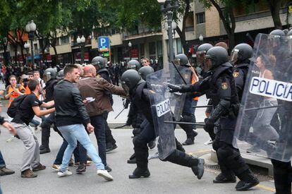 Agentes de la policía nacional intentan retirar a los concentrados en el instituto IES Tarragona.