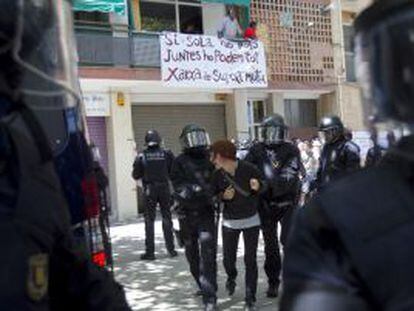 Mossos d'Esquadara detienen a una de las personas que intentaban evitar el deshaucio.