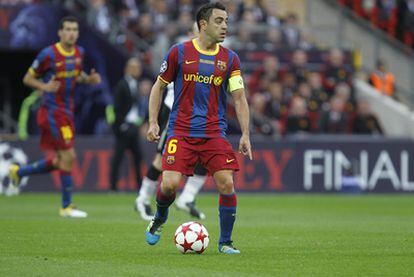 Xavi conduce el balón y da instrucciones durante el partido contra el Manchester