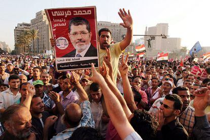 Unos manifestantes sostienen un cartel con el candidato del partido Libertad y Justicia, Mohamed, Morsi, mientras protestan contra la junta militar.