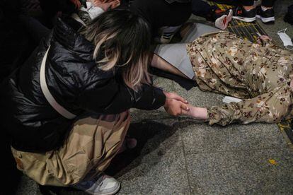 El ministro del Interior, Lee Sang-min, ha señalado que la Policía no contaba con que se congregasen grandes multitudes en las celebraciones de Halloween. En la imagen, una joven agarra la mano a una víctima.