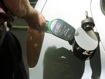 Trabajador de una estación de servico poniendo gasolina a un coche.