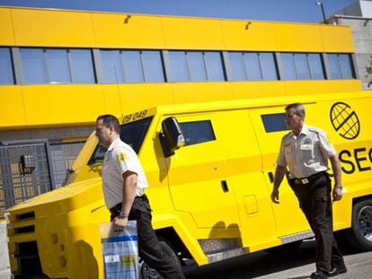 Dos trabajadores de Prosegur durante un servicio de traslado de dinero en efectivo.