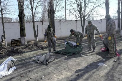 Soldados ucranios cubren los cuerpos de unos fallecidos tras el ataque ruso a una escuela militar en Mykolaiv, este sábado.