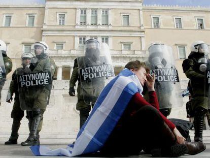Policias hacen guardia durante el desarrollo de una protesta frente al parlamento griego en Atenas