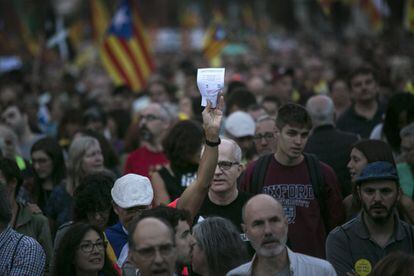 Un hombre muestra una papeleta como las utilizadas en el referéndum durante la manifestación a su paso por el Arco del Triunfo, en Barcelona.